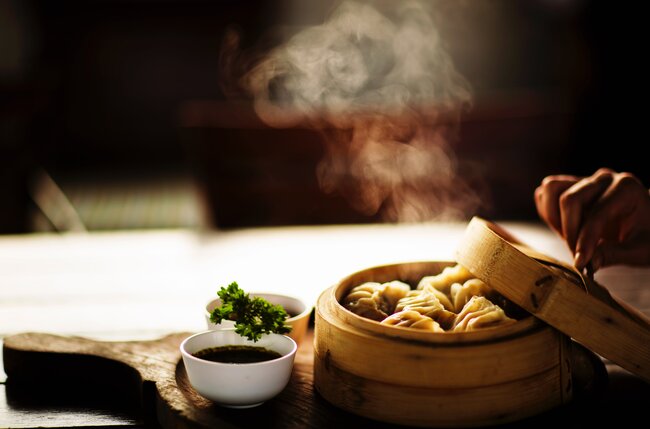 Fresh dumplings in steamer with soy and chilli sauce