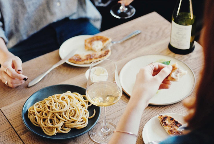 people enjoying wine and pasta at a restaurant in melbourne