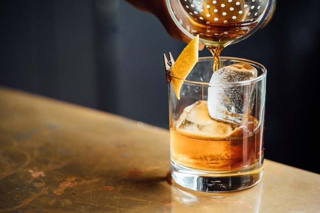 old fashioned cocktail being poured