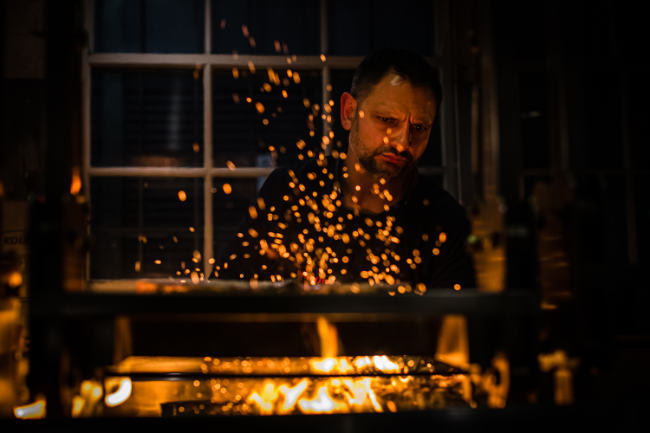 Chef cooking as flames rise up in front of him
