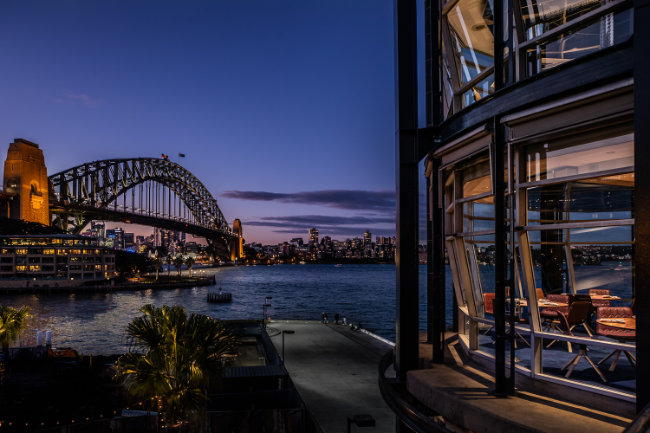Outside view of a restaurant overlooking the Sydney Harbour Bridge at night time 