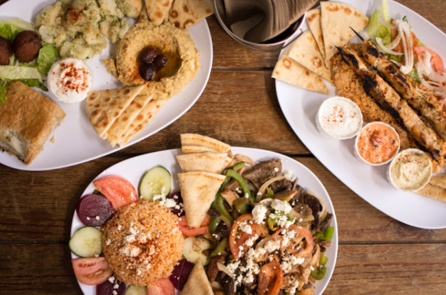 3 plates of pita bread, dips and fresh vegetables