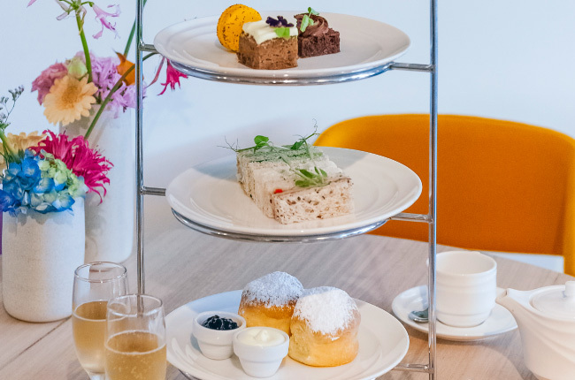 3 tiers of delicious sweets next to a cup of tea