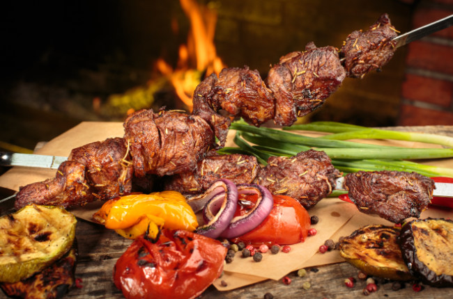 delicious meat on a skewer with fire in the background