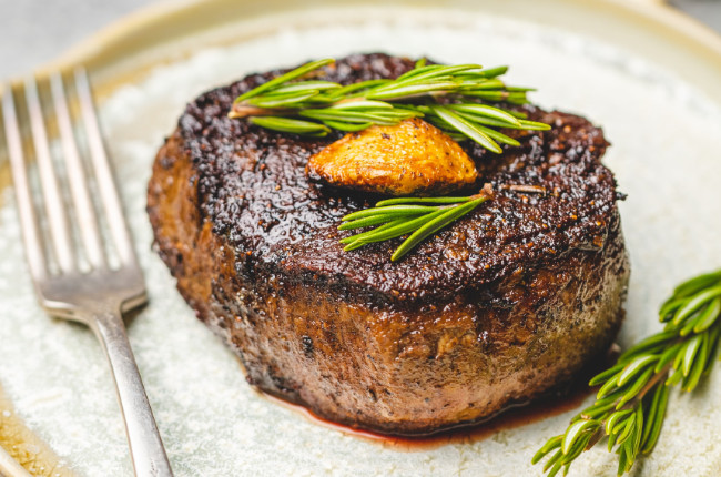 a perfectly cooked steak with rosemary