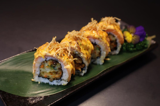tempura fried sushi resting on a banana leaf
