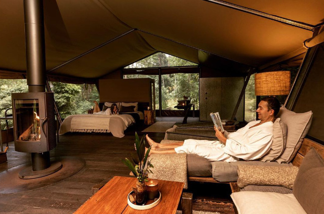 a couple relaxing inside a glamping text