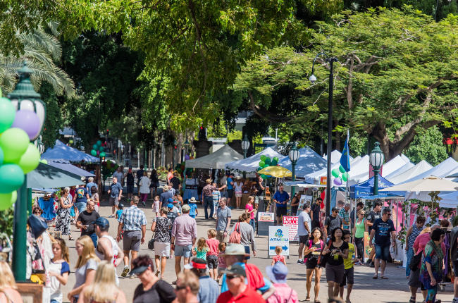 a large crowd of people enjoying the sun at riverside markets