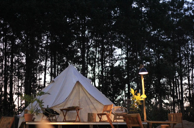 the outside of a glamping tent as the sun goes down