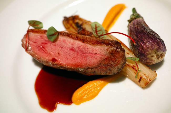 a delicious steak dressed with sauce and vegetables