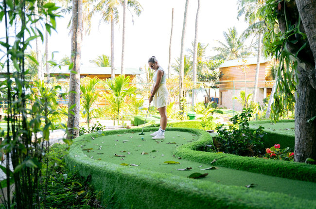 a woman about to putt a golf ball
