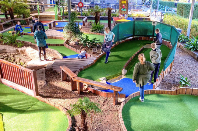 a family enjoying a game of mini golf