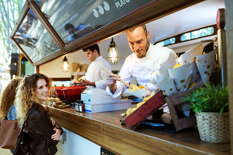 a chef serving food to a lady
