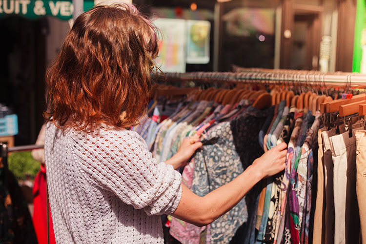 a woman rifling through clothing at kensington market