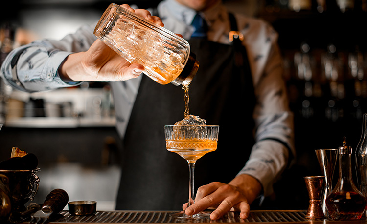 a waiter pouring a cocktail in a restaurant
