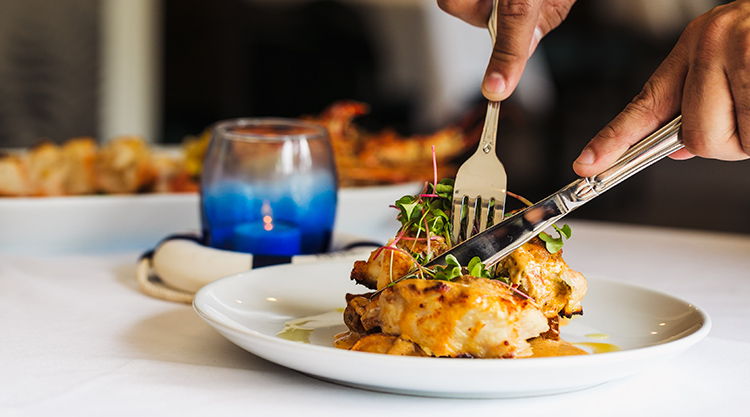 using cutlery to cut into fancy food at a restaurant