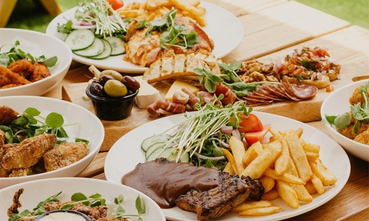 a plate filled with hamburgers, steaks and fries