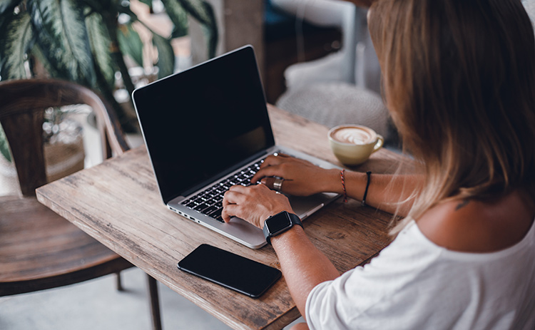 a woman sitting on her laptop at a cafe
