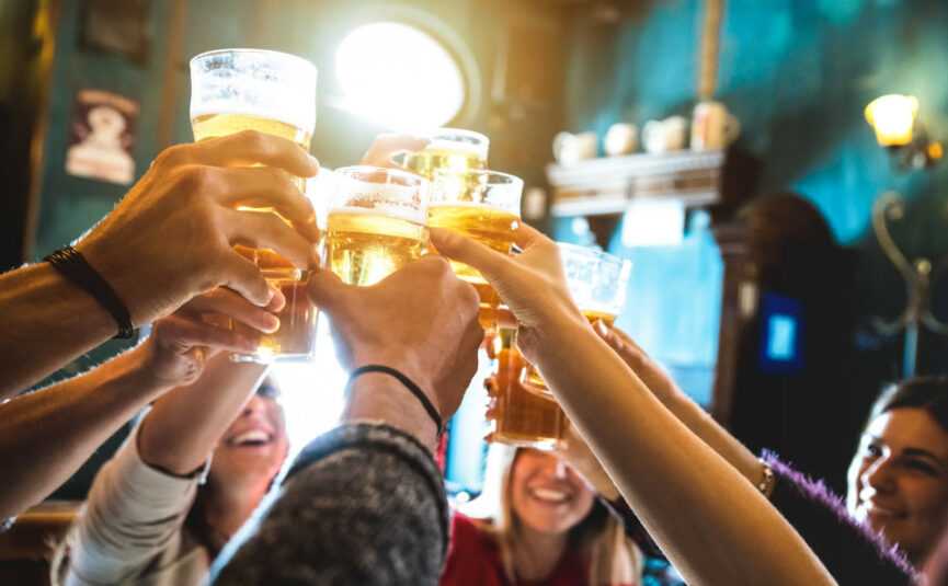 people holding pints of beer at a at brewery bar